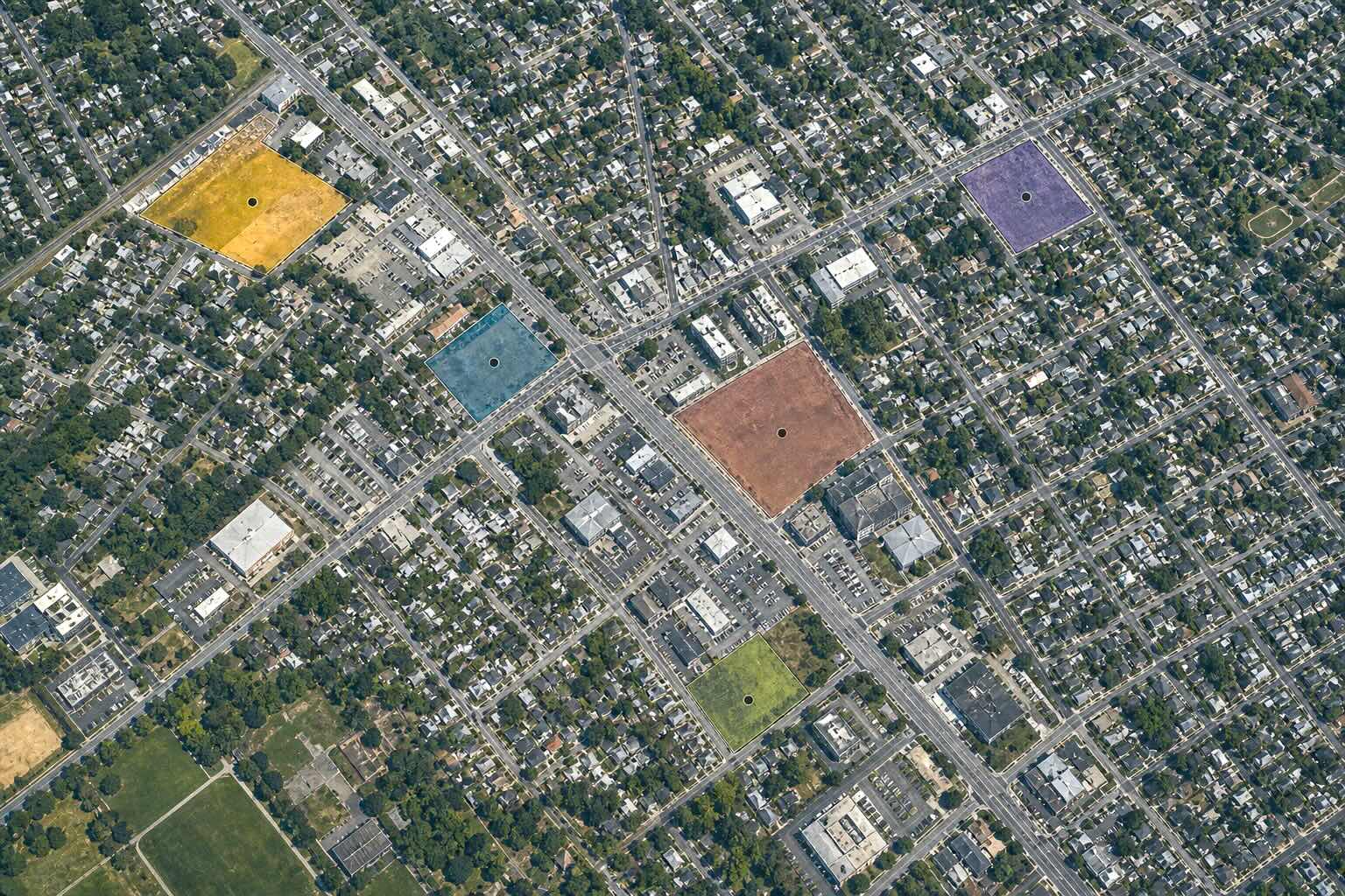 Aerial GIS view of an urban area with multiple development sites highlighted for comparison.